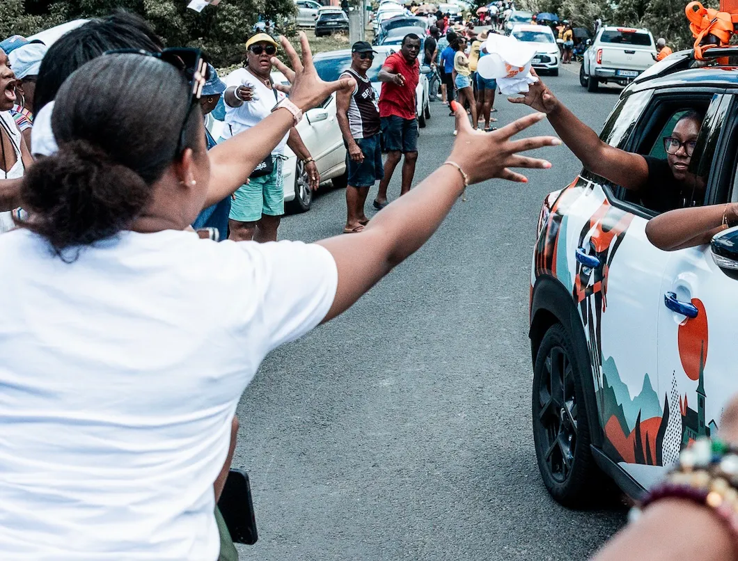 Une spectatrice tend les bras vers un véhicule de la caravane du Tour.