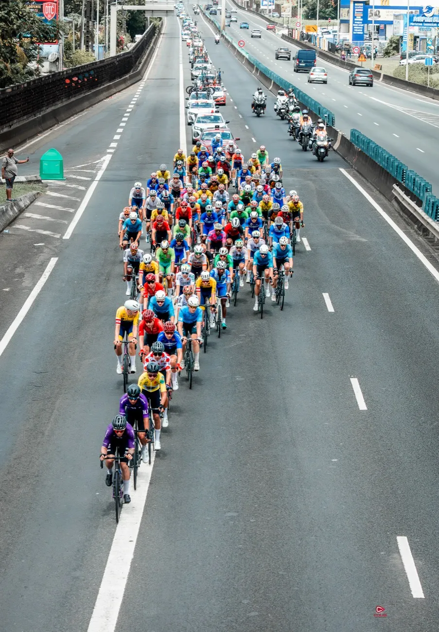 Le peloton du Tour cycliste de la Guadeloupe en pleine ascension sur la rocade, vu depuis le dispositif de course